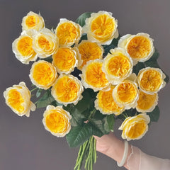 Beatrice rose bouquet with green leaves, white outer petals and bright yellow centers